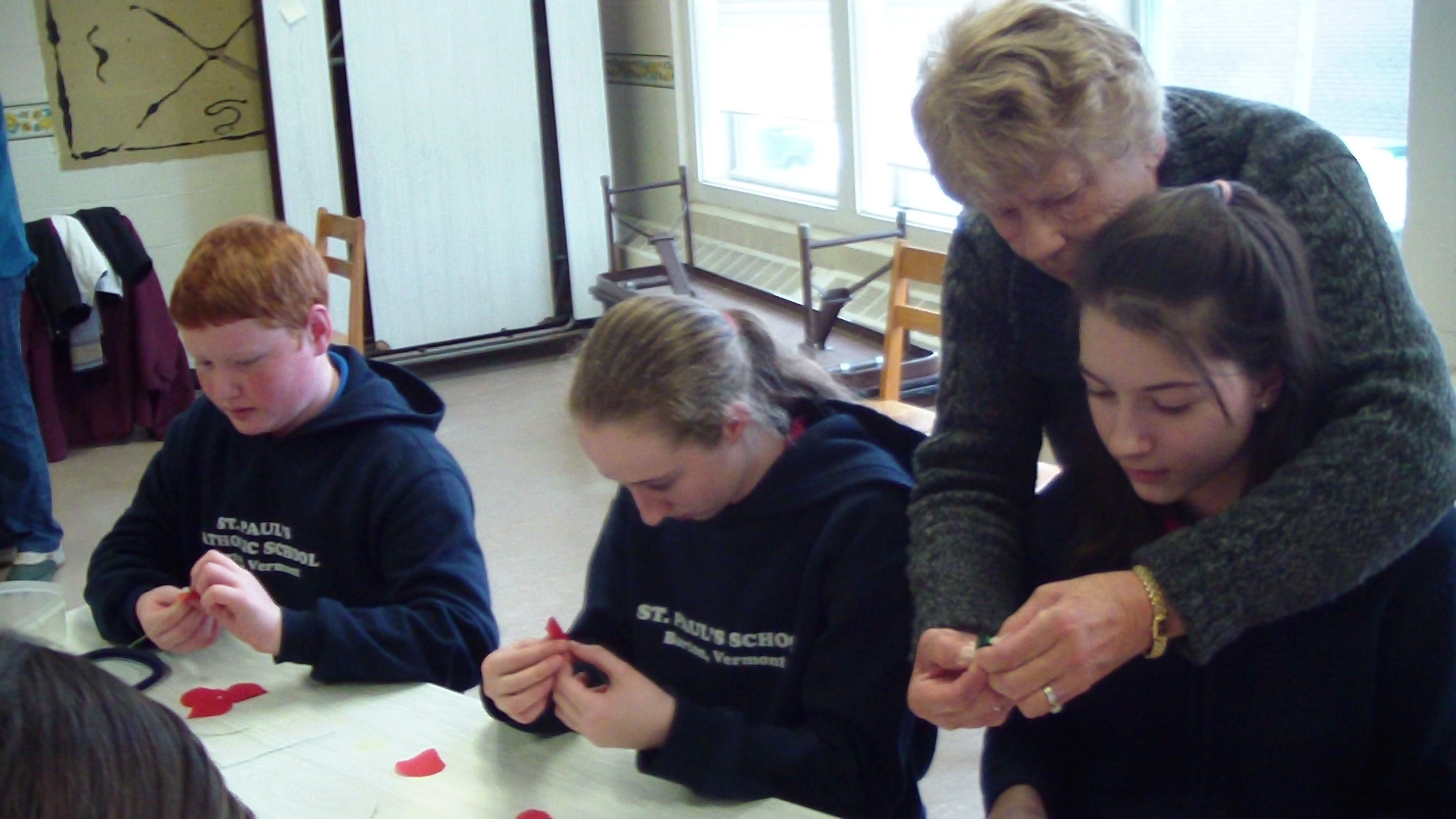 7th and 8th graders making poppies with members of the American Legion Aux.